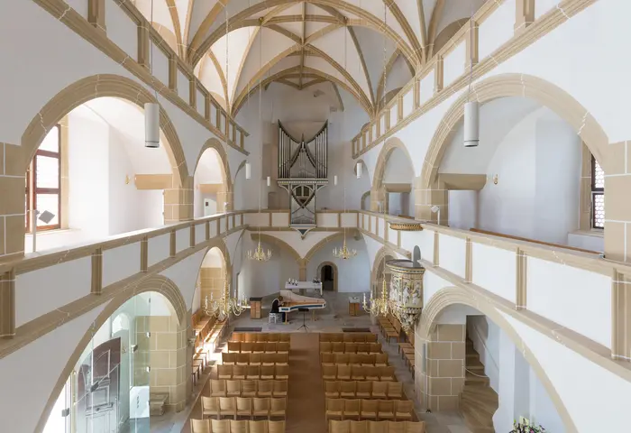 Blick von oben auf Innenraum der Kapelle, jemand spielt Klavier