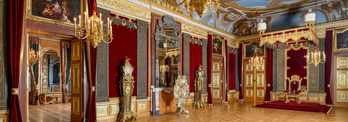 Großer, prunkvoller Raum mit Thron, Kerzenleuchter und Deckenmalerei