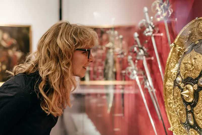 Besucherin betrachtet aufwendig verziertes Schild