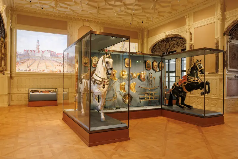Vitrine mit zwei Pferden, im Hintergrund eine Projektion des Schlosses an der Wand